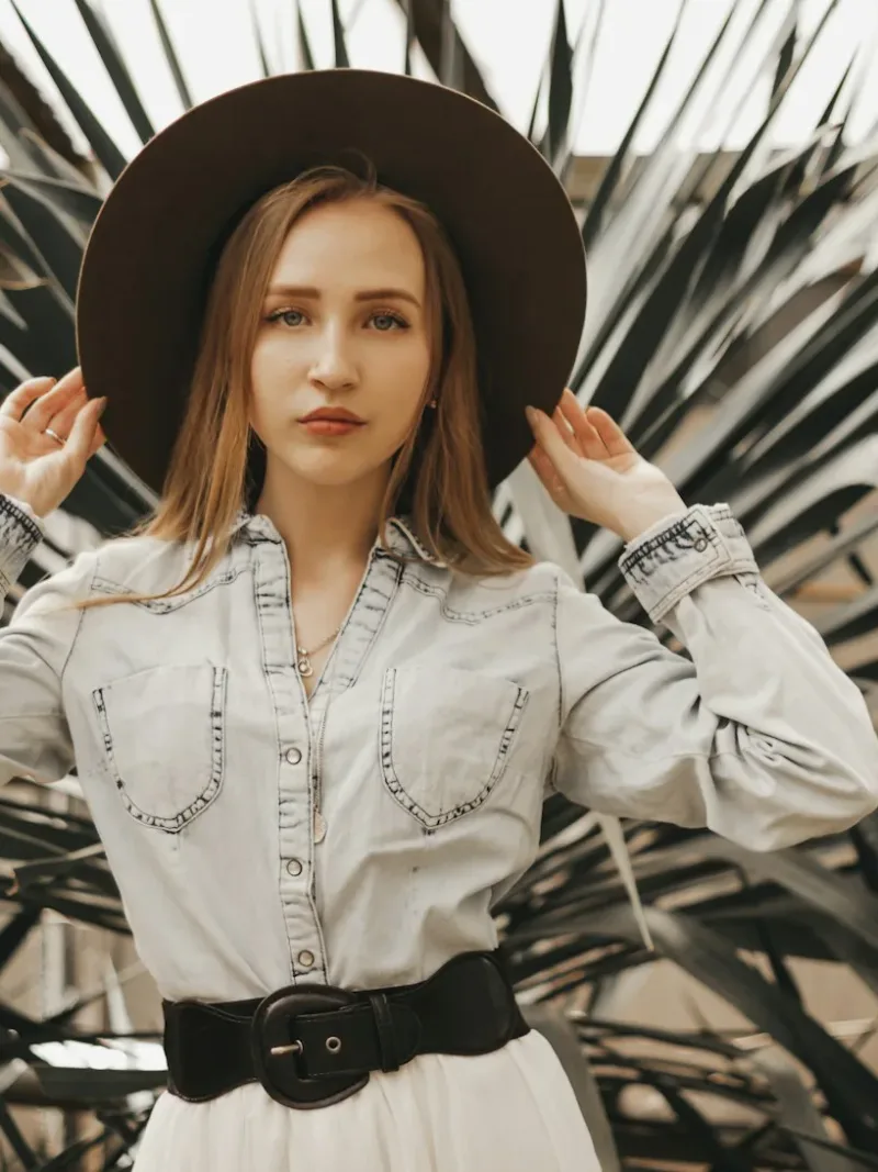 White pearl snap western shirt with a black belt and felt hat