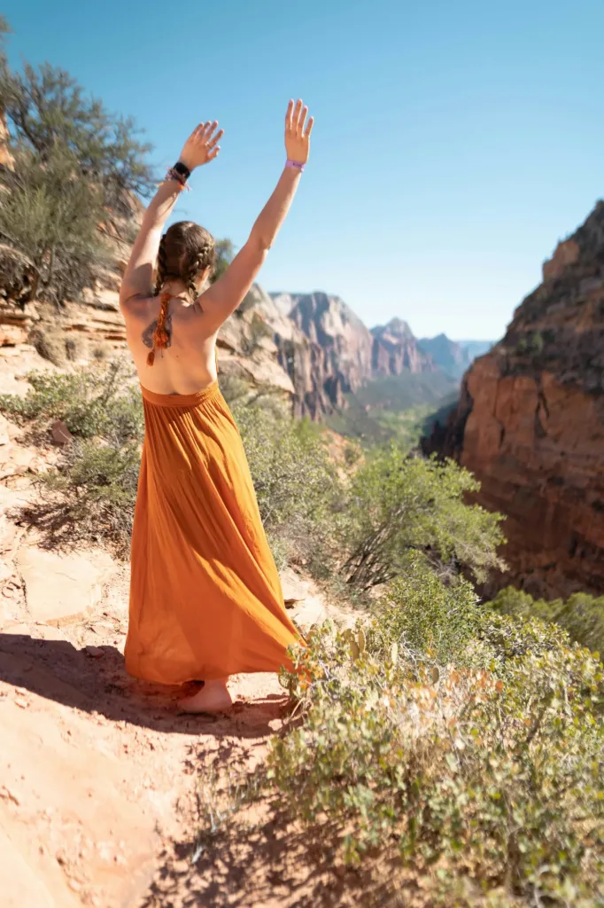Flowing terracotta maxi dress in a canyon at golden hour