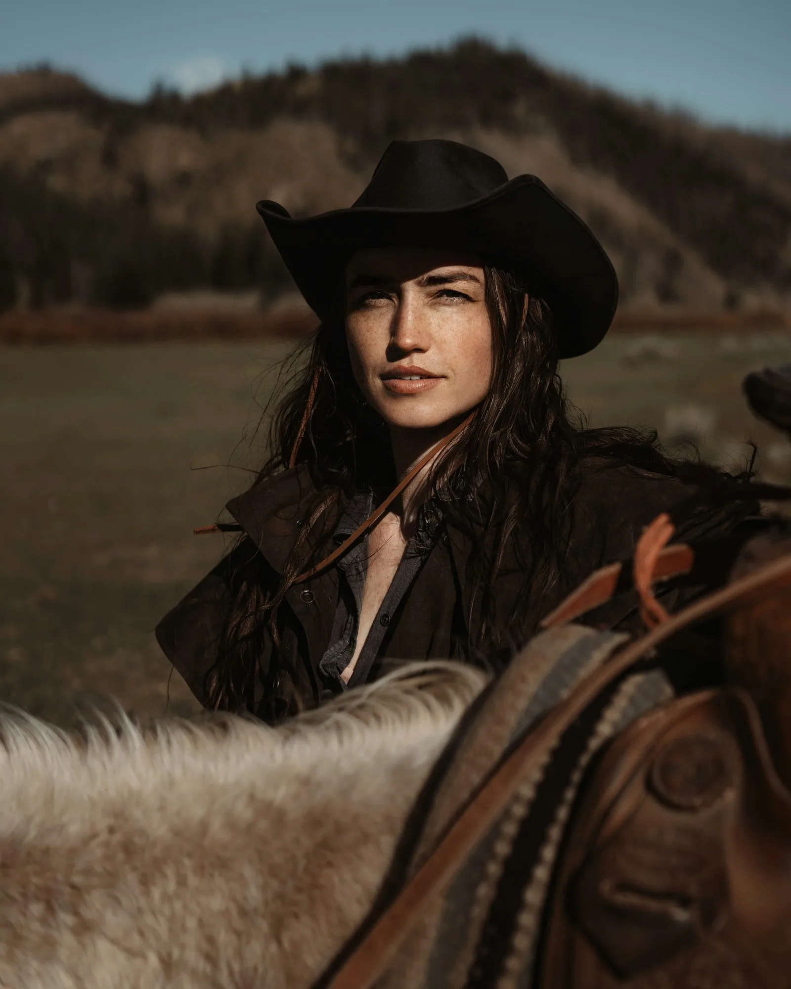 Black felt cowgirl hat worn horseback in the foothills