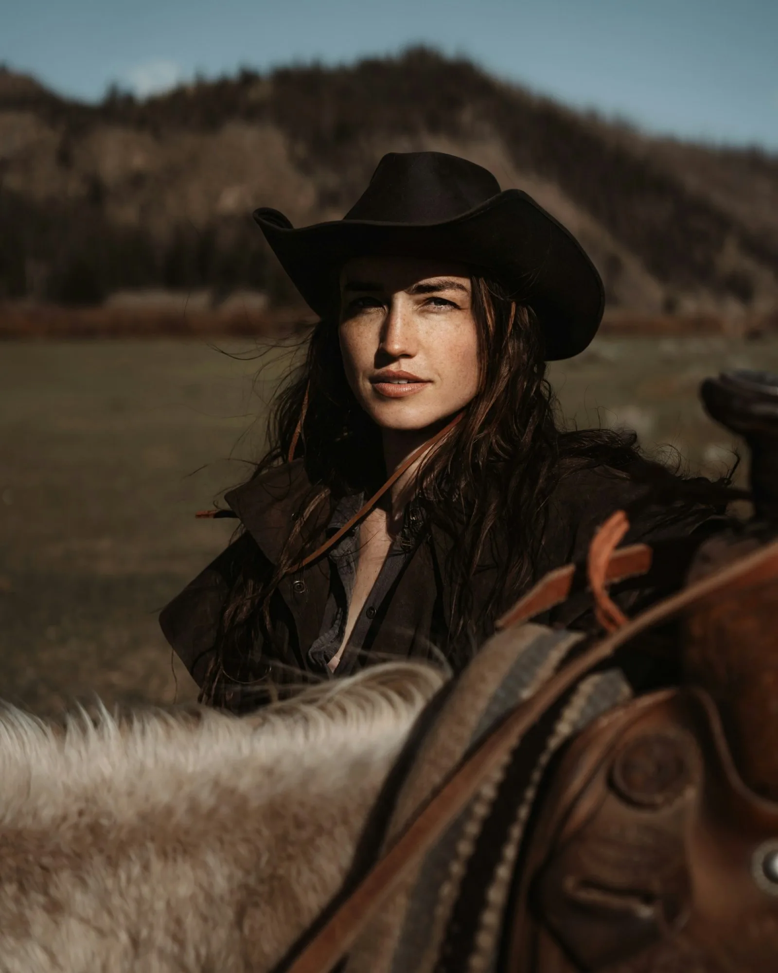 Black felt cowgirl hat three-quarter view on horseback