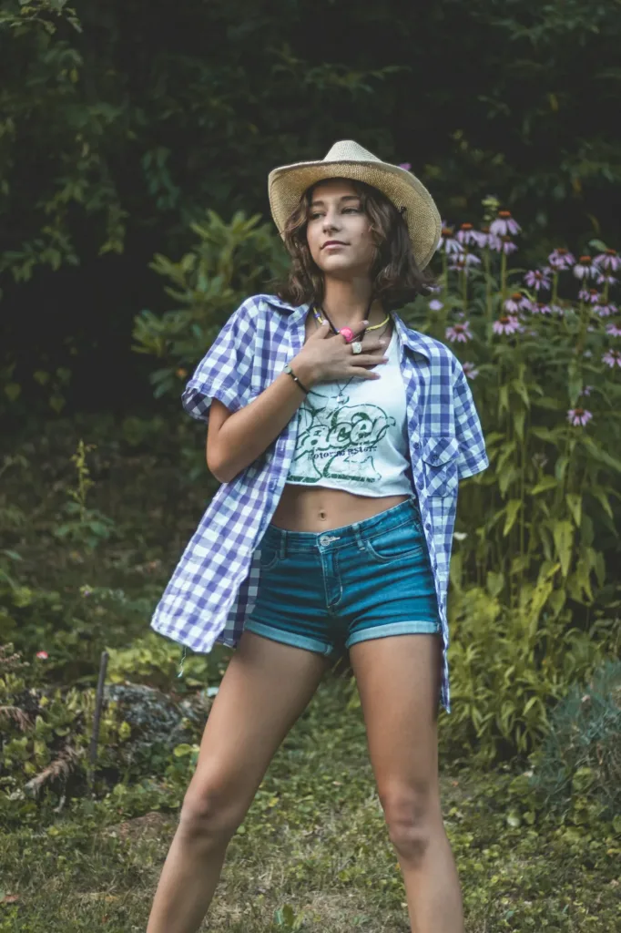 Gingham shirt with denim shorts and a straw hat in the garden